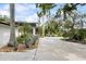 View of the house with a long driveway and lush landscaping with green lawn at 3130 Walnut Ne St, St Petersburg, FL 33704