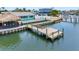 Waterfront backyard featuring large dock, tiki hut, outdoor seating, and lush landscaping at 326 176Th Avenue Cir, Redington Shores, FL 33708