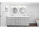 Bathroom featuring a double sink vanity with round mirrors and modern fixtures at 326 176Th Avenue Cir, Redington Shores, FL 33708