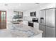 Updated kitchen featuring stainless appliances, marble counters, and white cabinets at 326 176Th Avenue Cir, Redington Shores, FL 33708
