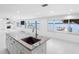 Bright open kitchen featuring a large island, stone countertops, and waterfront views from multiple windows at 326 176Th Avenue Cir, Redington Shores, FL 33708