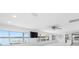 Spacious living room with white walls, ceiling fan, and waterfront views through large windows at 326 176Th Avenue Cir, Redington Shores, FL 33708