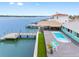 Waterfront house featuring a covered tiki bar, a pool, a dock and outdoor seating at 326 176Th Avenue Cir, Redington Shores, FL 33708