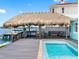 Outdoor pool area with a covered tiki bar and lounge at 326 176Th Avenue Cir, Redington Shores, FL 33708