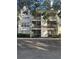 Condo building featuring balconies and outdoor living, lush landscaping and ample parking at 3260 Haviland Ct # 202, Palm Harbor, FL 34684