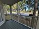 View from a screened-in patio with wooden floors, showing street and mature trees at 3260 Haviland Ct # 202, Palm Harbor, FL 34684