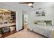 Bedroom with hardwood floors, a ceiling fan, and a view into a closet and a bathroom at 3417 W Alline Ave, Tampa, FL 33611
