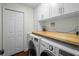 Functional laundry room with washer, dryer, wood countertop and built-in cabinets at 3417 W Alline Ave, Tampa, FL 33611
