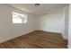 Bright bedroom featuring hardwood floors, white paint, and a window providing natural light at 3530 Umber Rd, Holiday, FL 34691