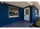 Charming blue home featuring a white door and manicured landscaping near the front entrance at 3530 Umber Rd, Holiday, FL 34691