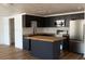 Modern kitchen featuring dark cabinets, stainless steel appliances, and a kitchen island at 3530 Umber Rd, Holiday, FL 34691