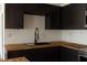 Modern kitchen featuring dark cabinets, stainless steel appliances, and butcher block countertops at 3530 Umber Rd, Holiday, FL 34691