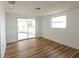 A spacious living room featuring hardwood floors and sliding glass doors leading to a patio at 3530 Umber Rd, Holiday, FL 34691