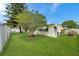 Lush green backyard with healthy lawn, privacy fence, and mature trees offering shade and visual interest at 3716 Carioca Rd, Holiday, FL 34691