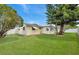 Well-maintained backyard featuring a lush lawn, a white fence, and mature trees, creating a private space at 3716 Carioca Rd, Holiday, FL 34691