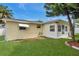Wide backyard view showcasing mature landscaping and the exterior of the house at 3716 Carioca Rd, Holiday, FL 34691