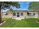 Backyard view featuring a well-maintained lawn and access door to the home at 3716 Carioca Rd, Holiday, FL 34691