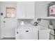 Bright laundry room with modern washer, utility sink, storage cabinets, and access to the outdoors at 3716 Carioca Rd, Holiday, FL 34691
