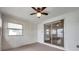 Bright sunroom with sliding glass doors, ceiling fan, neutral paint, and a glimpse into the home's interior at 3716 Carioca Rd, Holiday, FL 34691