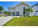 Charming two-story home featuring a well-manicured lawn, palm trees, and modern architectural details at 3801 Huntington Ne St, St Petersburg, FL 33703