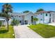 Attractive two-story home with a large driveway, mature palm trees, and contemporary design elements at 3801 Huntington Ne St, St Petersburg, FL 33703