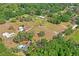 A landscape aerial view shows a property with a home, expansive yard, mature trees, and serene, wooded surroundings at 39427 Comstock Ln, Zephyrhills, FL 33540