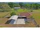 Expansive aerial view of the property featuring a home, carport, and lush green surroundings at 39427 Comstock Ln, Zephyrhills, FL 33540