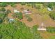 Wide aerial shot showcases a home with ample land, mature trees, and its location within a peaceful, wooded area at 39427 Comstock Ln, Zephyrhills, FL 33540