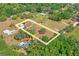 Birds-eye view of the property features a home and a expansive plot of land with lush, mature trees in a serene setting at 39427 Comstock Ln, Zephyrhills, FL 33540