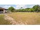 A spacious backyard enclosed by a fence, featuring a patio area and expansive grassy area perfect for outdoor activities at 39427 Comstock Ln, Zephyrhills, FL 33540