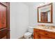 This half bath features granite vanity and a wood-framed mirror, offering a touch of warmth at 39427 Comstock Ln, Zephyrhills, FL 33540