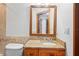This half bath features granite vanity and a wood-framed mirror, offering a touch of warmth at 39427 Comstock Ln, Zephyrhills, FL 33540