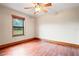 Bedroom with a ceiling fan, hardwood floors and window providing a view of the exterior at 39427 Comstock Ln, Zephyrhills, FL 33540