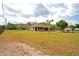 Single-story home featuring a large, well-maintained lawn, mature trees, and exterior featuring neutral color tones at 39427 Comstock Ln, Zephyrhills, FL 33540