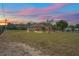 Serene home exterior at sunset, showcasing a spacious yard and peaceful rural setting at 39427 Comstock Ln, Zephyrhills, FL 33540