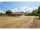 Spacious outdoor area featuring a horse barn, a large lawn and mature trees with ample parking at 39427 Comstock Ln, Zephyrhills, FL 33540