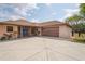Front exterior featuring a large parking pad, covered entry, and a two-car garage at 39427 Comstock Ln, Zephyrhills, FL 33540