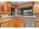 Kitchen sink with tile backsplash, granite countertop, window, and stainless steel dishwasher at 39427 Comstock Ln, Zephyrhills, FL 33540
