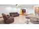 Open-concept living room boasts tile floors, leather sofas, and breakfast bar with bar stools at 39427 Comstock Ln, Zephyrhills, FL 33540