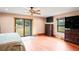 Bedroom with ceiling fan, a sliding glass door, hardwood floors, and two dressers at 39427 Comstock Ln, Zephyrhills, FL 33540