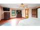 Spacious primary bedroom with hardwood floors, ceiling fan, TV, and en-suite bathroom at 39427 Comstock Ln, Zephyrhills, FL 33540