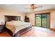 Primary bedroom with a large bed, a window and sliding glass door to the back yard at 39427 Comstock Ln, Zephyrhills, FL 33540