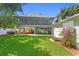 A boat and trailer are stored under the elevated living space in this lush backyard with a storage shed at 4027 Alabama Ne Ave, St Petersburg, FL 33703