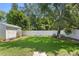 This backyard features a storage shed, green grass, white fencing, and a seating area at 4027 Alabama Ne Ave, St Petersburg, FL 33703