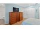 Bedroom with wood floors, a TV, dresser, and closet with louvered doors at 4027 Alabama Ne Ave, St Petersburg, FL 33703