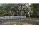 The spacious, tree-lined backyard features a well-maintained lawn and a classic white picket fence at 4872 Silverthorne Ct, Oldsmar, FL 34677