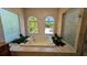 Bright bathroom featuring a soaking tub, tile flooring, and decorative frosted windows with a view at 4872 Silverthorne Ct, Oldsmar, FL 34677
