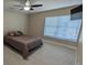 Bedroom with ceiling fan, gray wood-look floors, and large window with blinds at 4872 Silverthorne Ct, Oldsmar, FL 34677