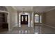 Grand foyer showcases decorative glass double doors, marble floors, and elegant chandelier at 4872 Silverthorne Ct, Oldsmar, FL 34677