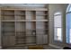 Living room showcases a large built-in bookshelf with cabinets and window with blinds at 4872 Silverthorne Ct, Oldsmar, FL 34677